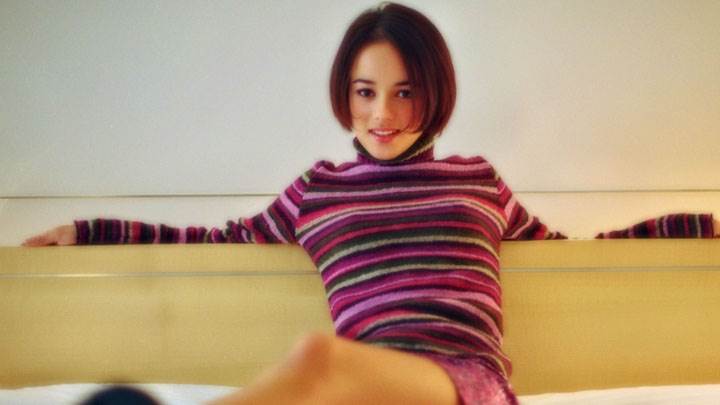 Alizee Jacotey Sitting On Bed In Colorful Top And Skirt