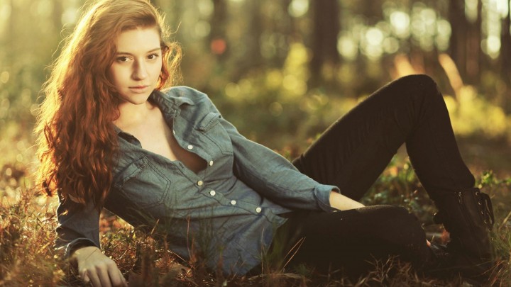 Golden Curly Haired Girl Laying On The Grass