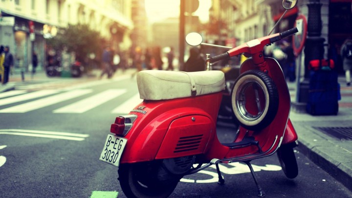 Red Vespa Standing On The Road Side
